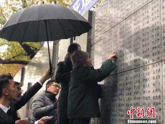 夏淑琴老人用手撫摸著親人的名字?！≈鞎苑f 攝