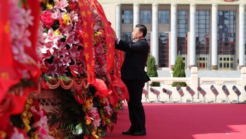 9月30日上午，習(xí)近平等黨和國(guó)家領(lǐng)導(dǎo)人來(lái)到北京天安門廣場(chǎng)，出席烈士紀(jì)念日向人民英雄敬獻(xiàn)花籃儀式。這是習(xí)近平整理花籃上的緞帶。圖片來(lái)源：新華社